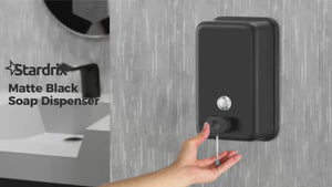 Hand using matte black wall mounted hand soap dispenser
