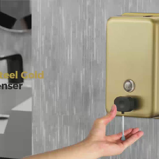 Hand using brushed gold bathroom soap dispenser
