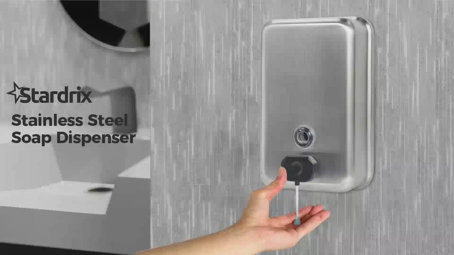Hand using ST1100V manual soap dispenser on a restroom wall
